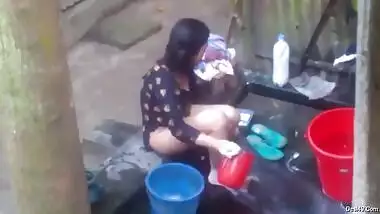 Naked Desi woman washes XXX assets outdoors not knowing about camera